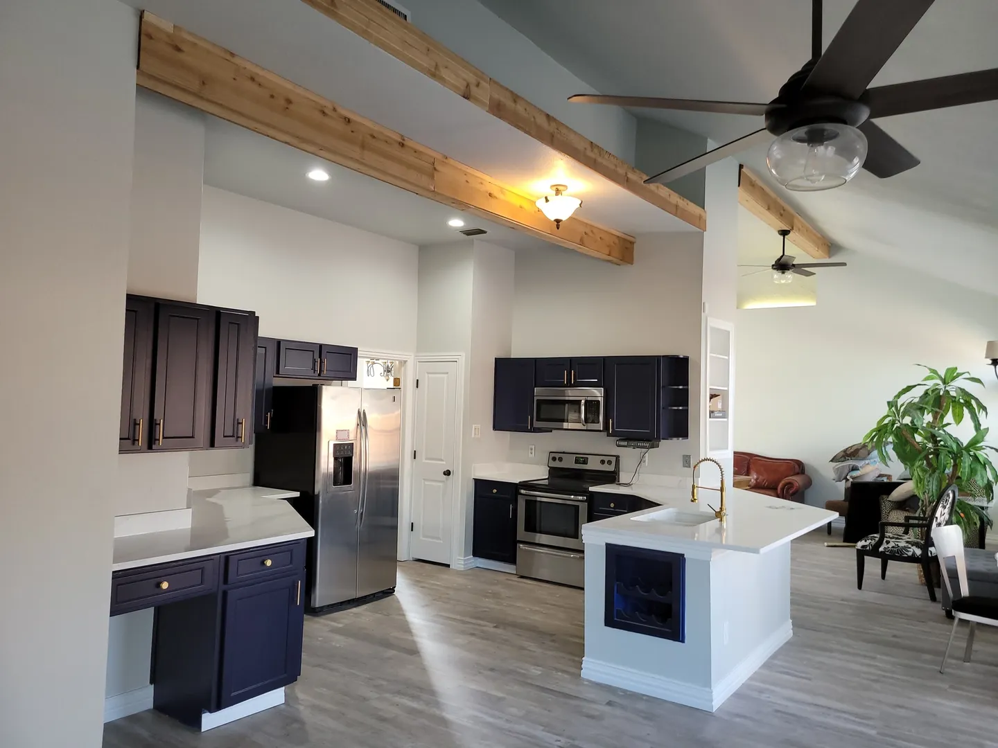 A kitchen with black cabinets and white walls.