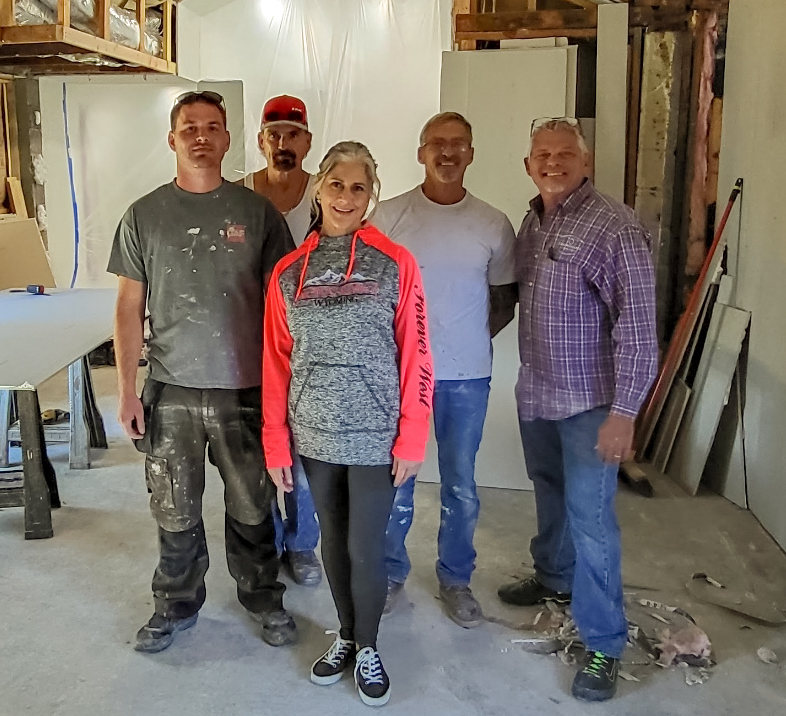 A group of people standing in the middle of a room.